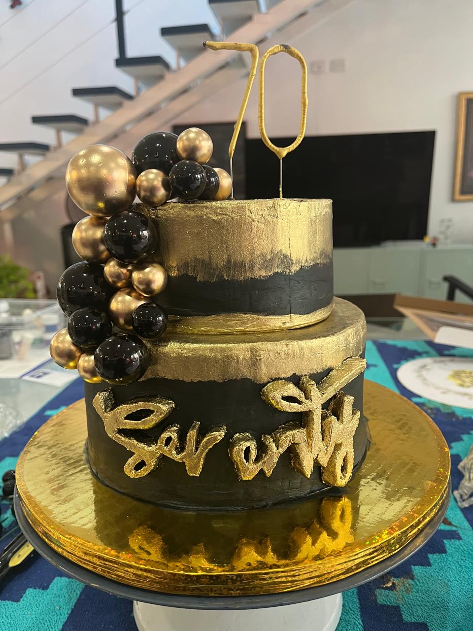 A happy birthday cake for a 70 year old with a hat and decorations